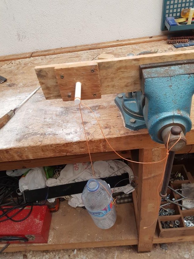 Chalk sample clamped as a cantilever with a water bottle hanging as the load