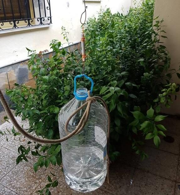 Chalk sample hanging from a hook with wire knots, a water bottle hanging below